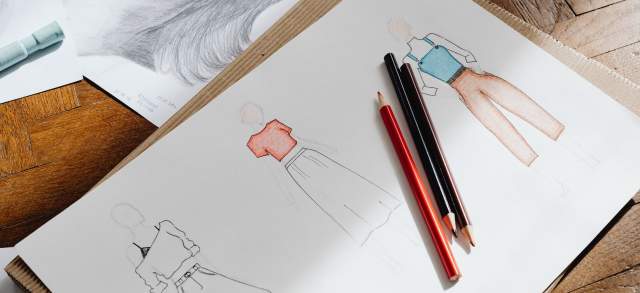 Aufgeschlagene Bewerbungsmappe mit Zeichnungen für ein Designstudium.