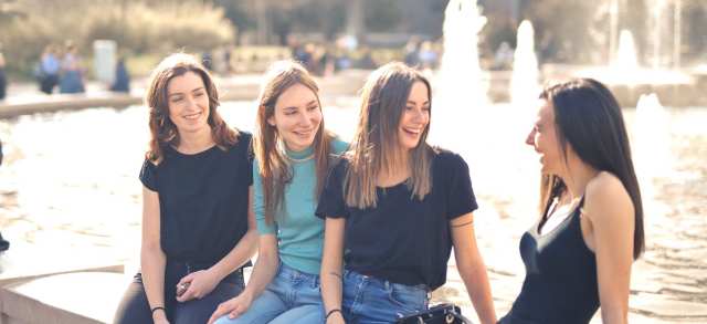 Fröhliche Gruppe junger Frauen am Brunnen freut sich über den freien Zugang zu zulassungsfreien Studiengängen.