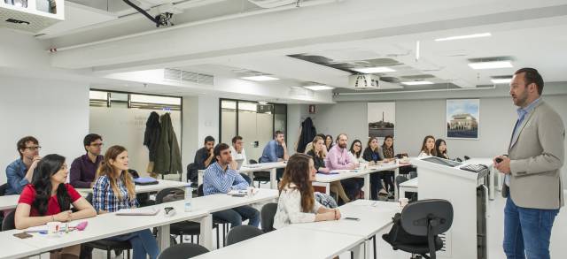 MBA-Student*innen zusammen mit ihrem Dozenten in einer Vorlesung.