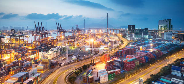 Blick von oben auf einen Hafen mit Kränen und Containern