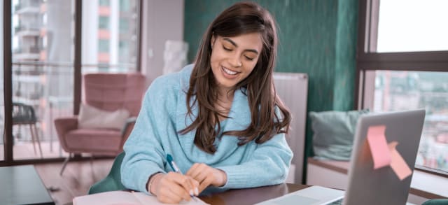 Junge Frau lernt am Laptop für ihr berufsbegleitendes Studium.