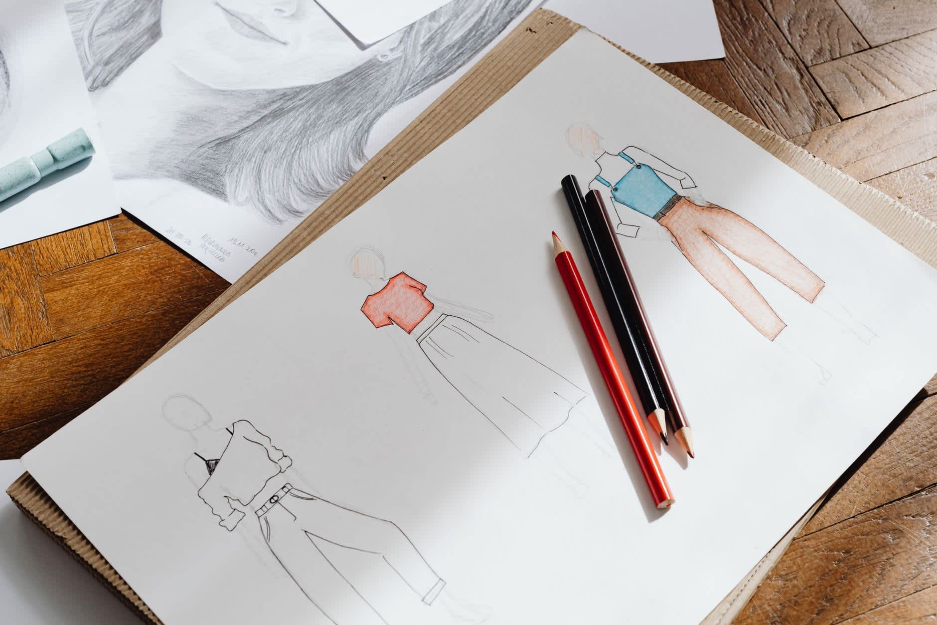 Aufgeschlagene Bewerbungsmappe mit Zeichnungen für ein Designstudium.