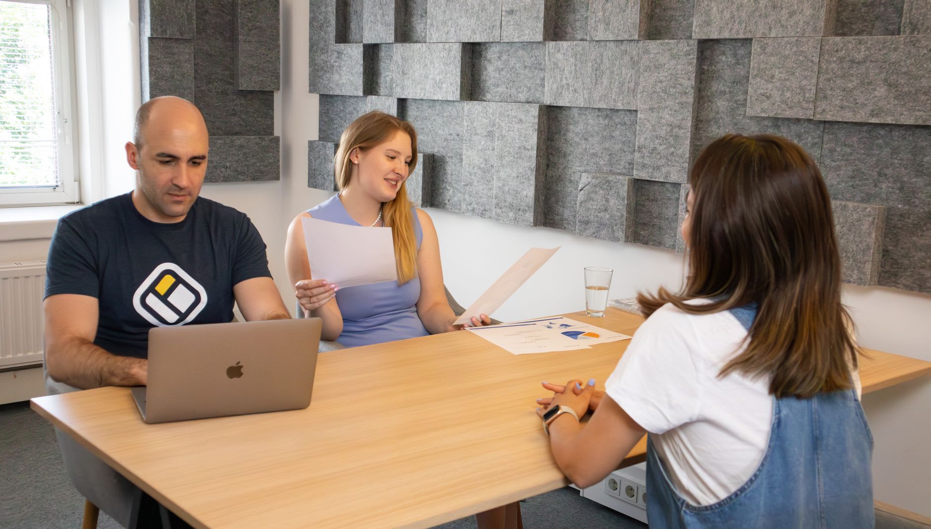 Drei Personen sitzen an einem Tisch im Gespräch und nutzen eine persönliche Studienberatung.