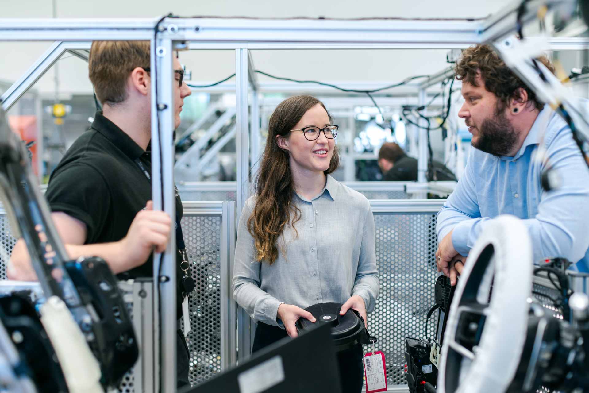 Female electronics engineer tests vehicle sound systems with team