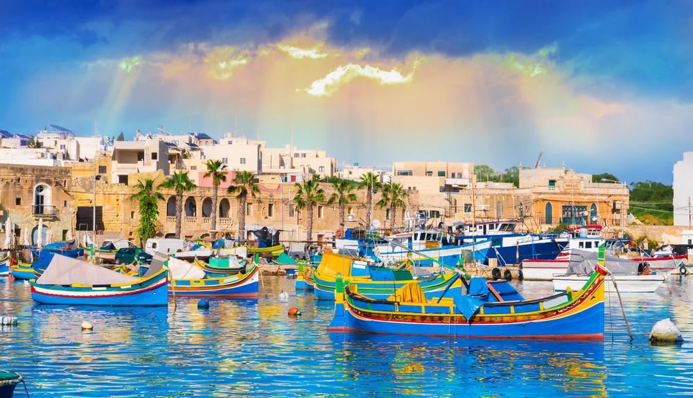 Marsaxlokk village harbor of Malta, illuminated by sunset light