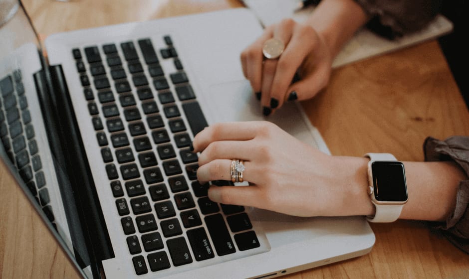 Woman's hands typing on a keyboard