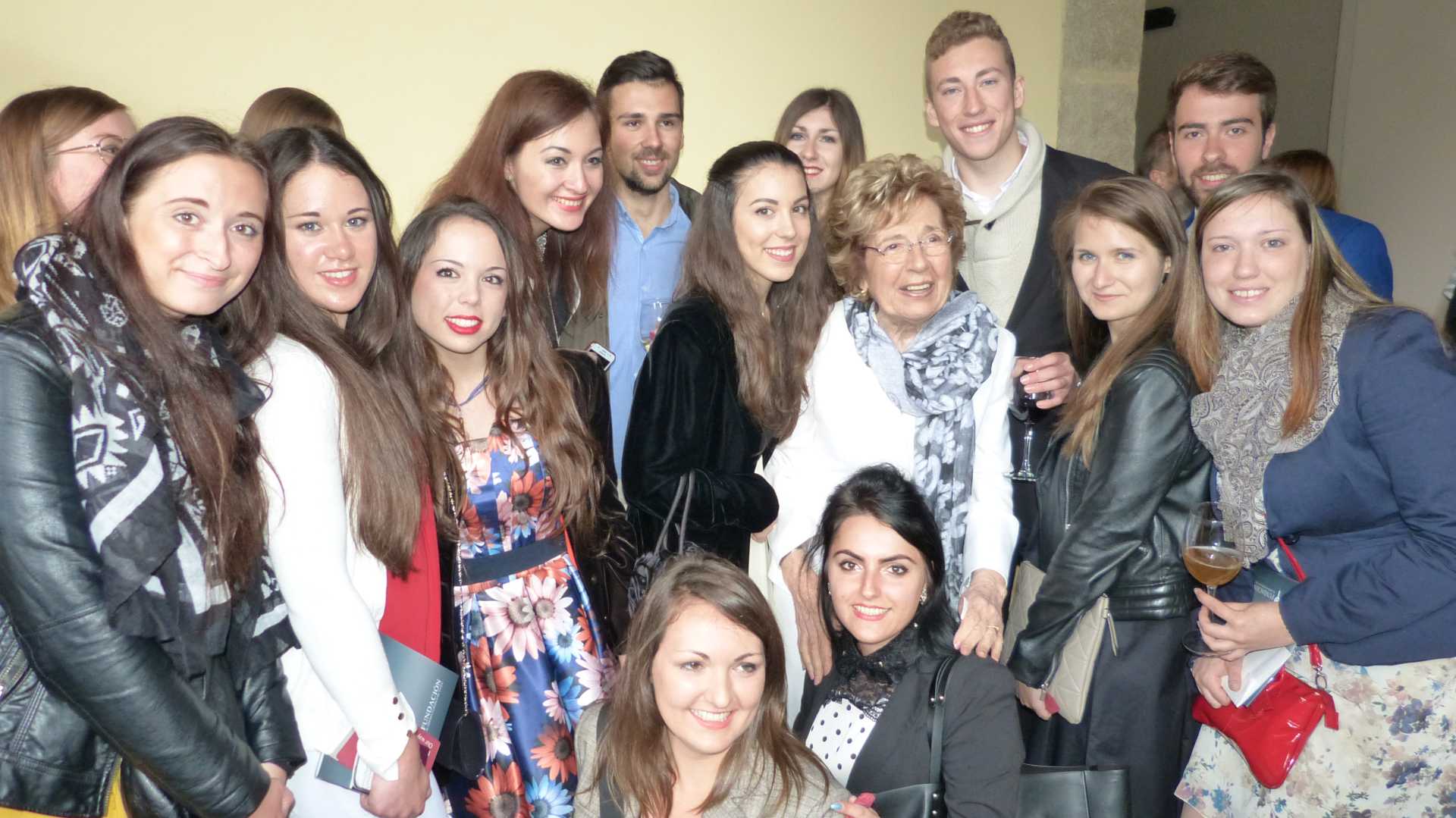 Sofia Corradi, founder of the Erasmus program, surrounded by smiling students.
