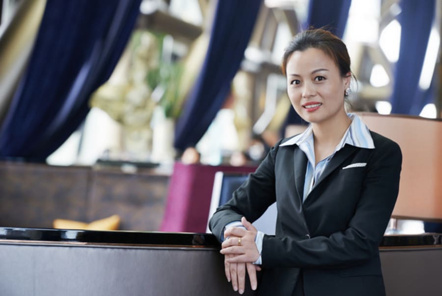 Portrait of a young businesswoman in suit standing at hotel interior