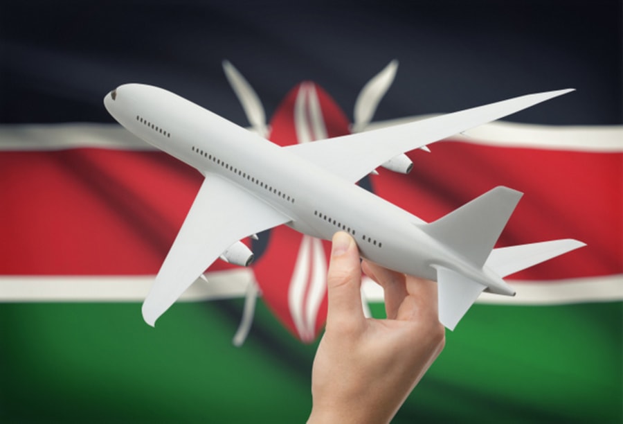 Airplane in hand with national flag on background - Kenya