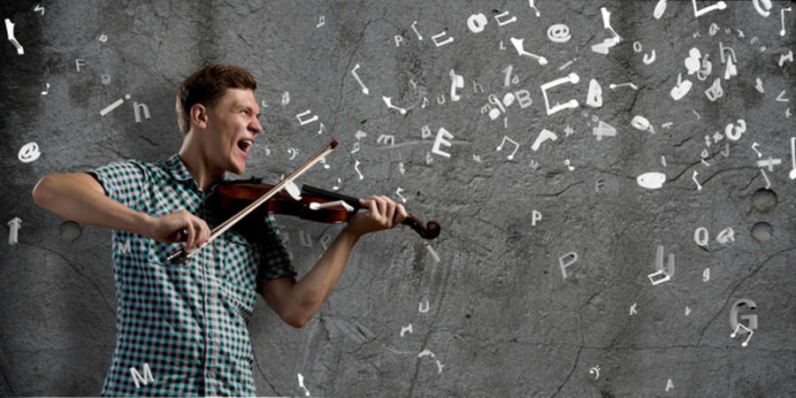 Young handsome guy on cement background with violin