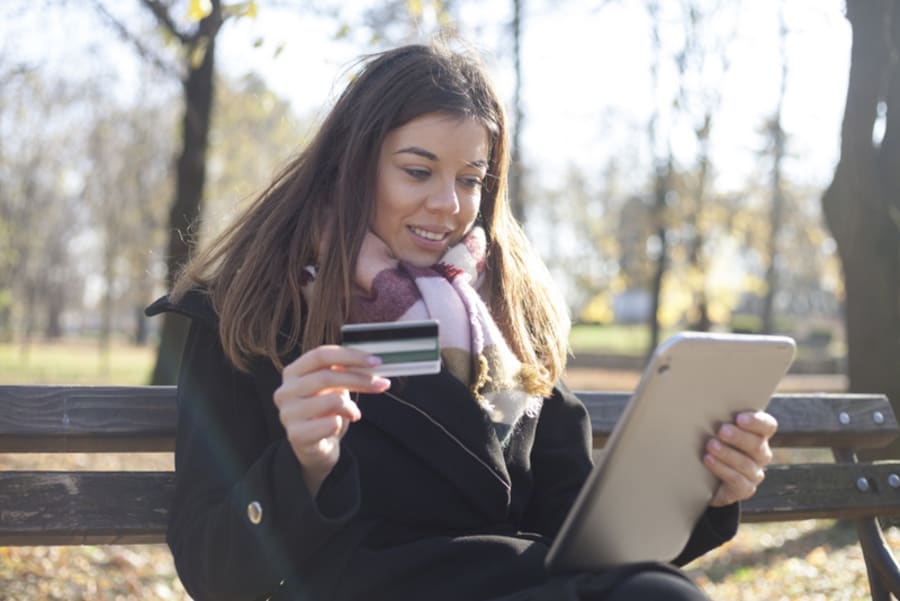 Young business woman in the park buys online, Selective focus an