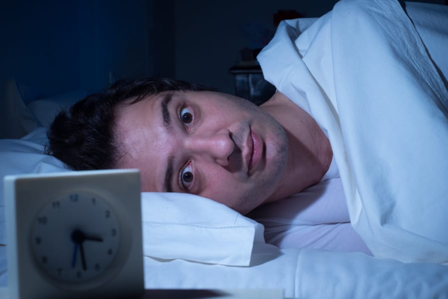 Stressed man suffering for insomnia can't sleep in his bed