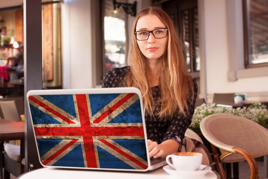 Woman in  cafe notebook with flag of Britain