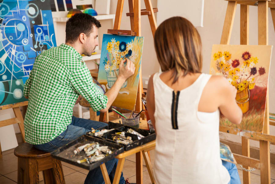 Young adults painting at an art school
