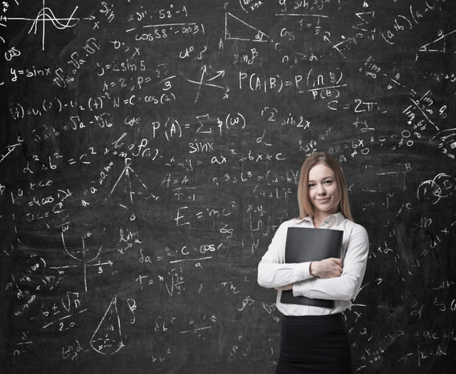 Beautiful blonde business woman is holding a black document case. Drawn mathematics equations and formulas on the chalk wall.