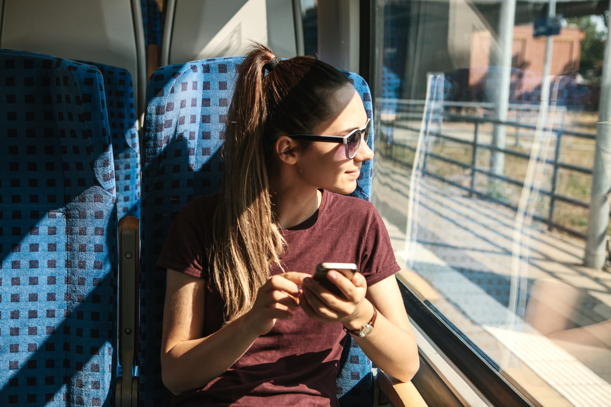 Una turista en el tren utiliza un teléfono móvil.