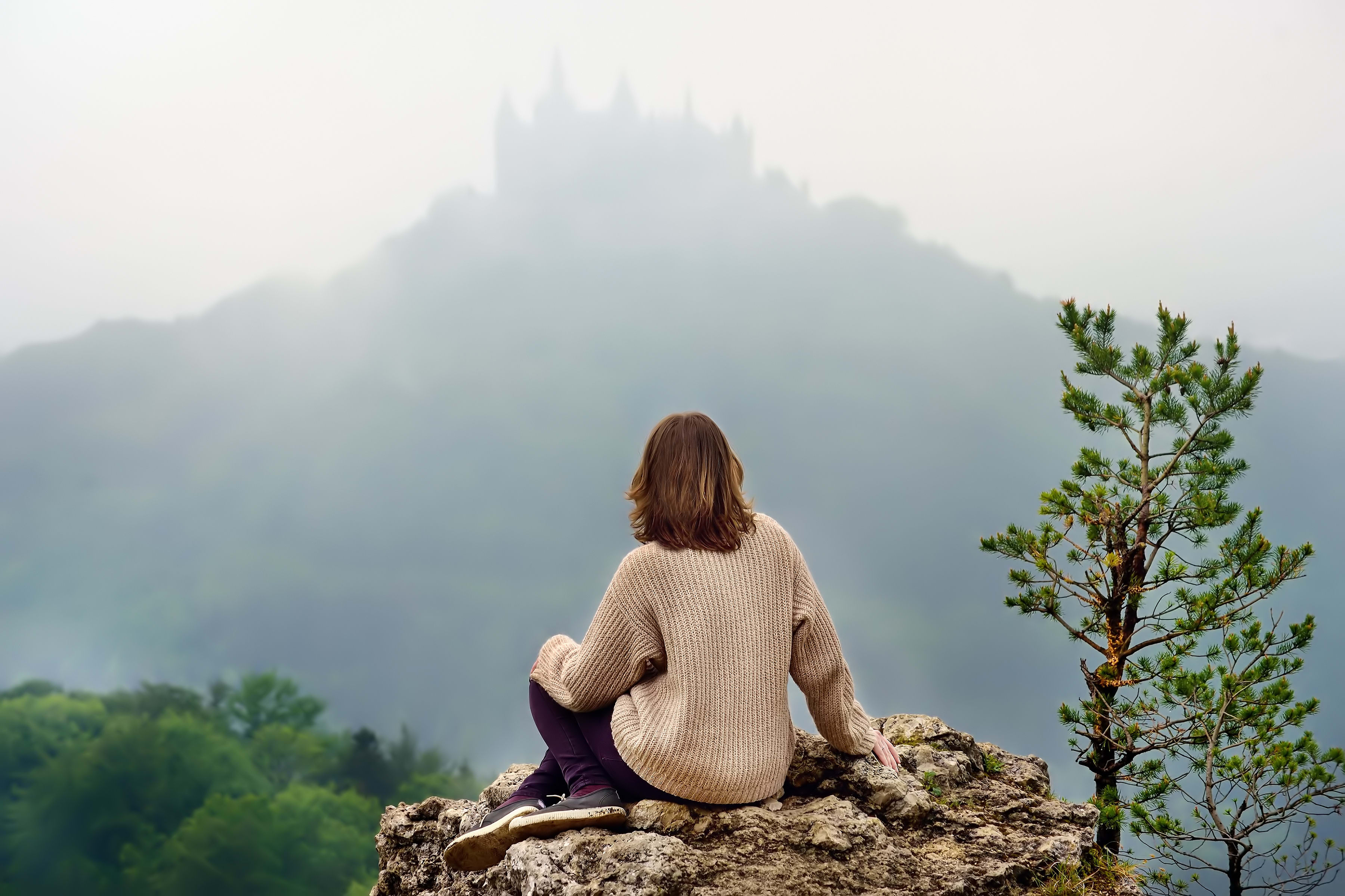 Joven turista mirando el famoso castillo de Hohenzollern en medio de una espesa niebla, Alemania