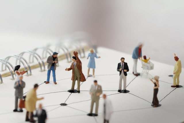 close up of miniature people with social network diagram on open notebook on wooden desk as social media conept