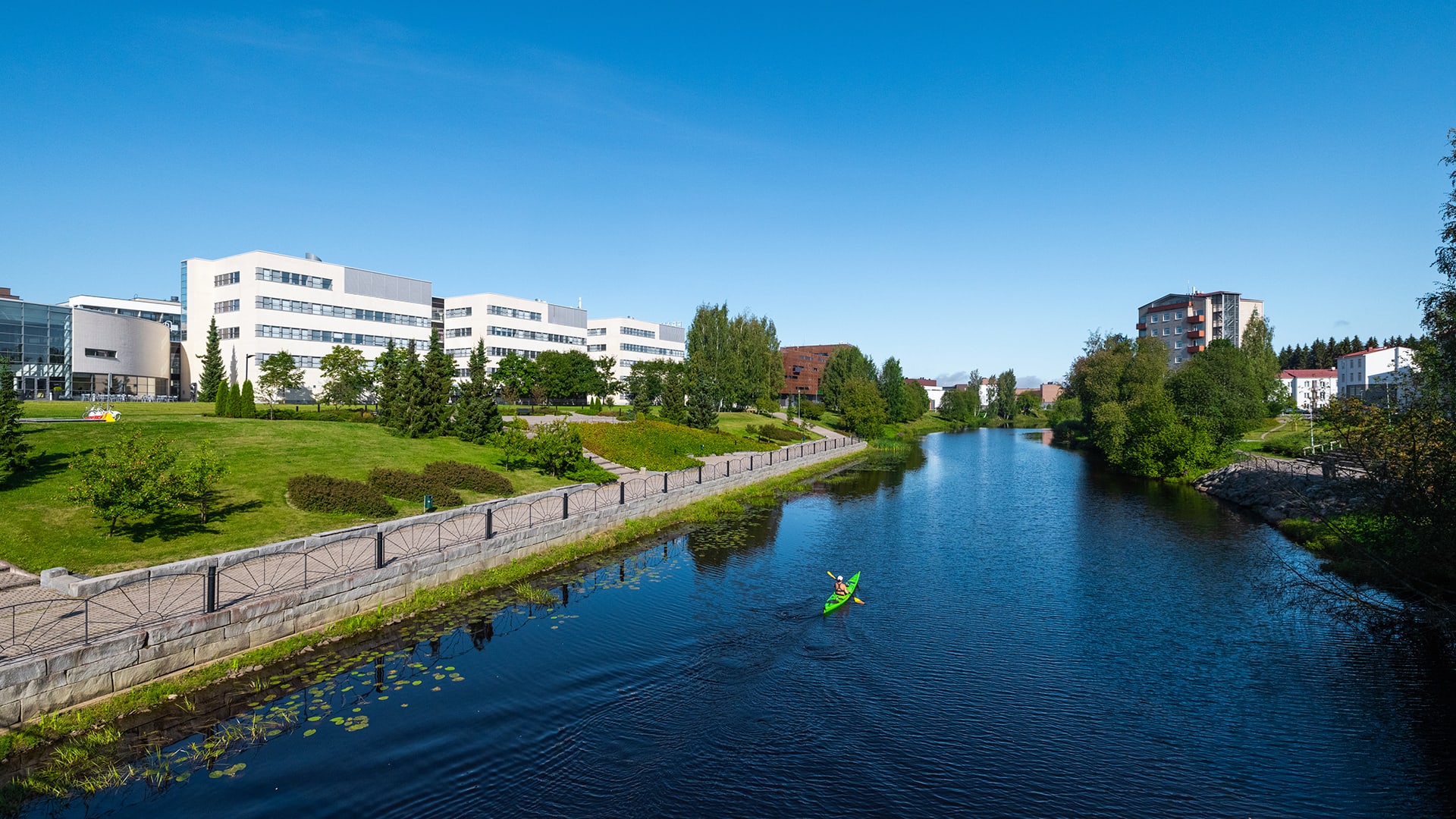 White campus buildings on both sides of a river.