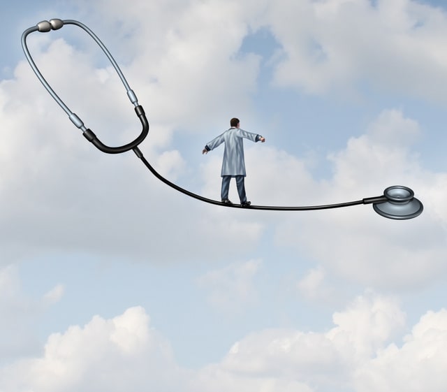 Medical decisions health care concept with a doctor in a lab coat walking a tight rope made from a stethoscope on a blue sky background as a metaphor for hospital therapy risk versus benefit as a balancing act for successful patient therapy.