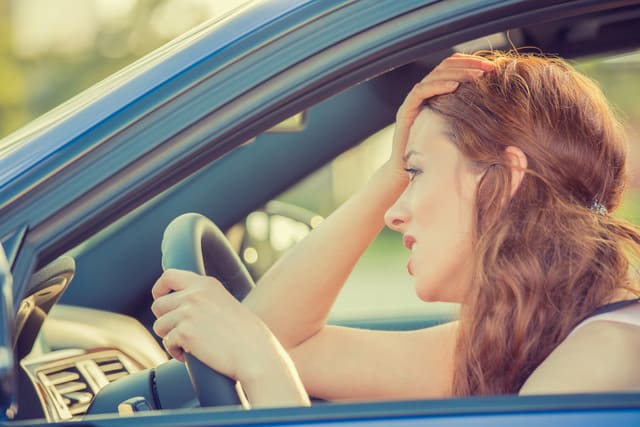 Side view window portrait displeased young stressed angry pissed off woman driving car annoyed by heavy traffic. Emotional intelligence concept. Negative human face expression