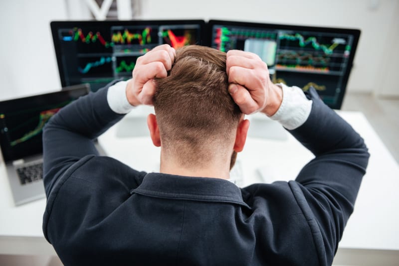 Stressed irritated businessman sitting and working with computer in office