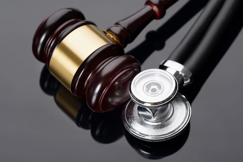 Close-up Of Brown Gavel And Medical Stethoscope