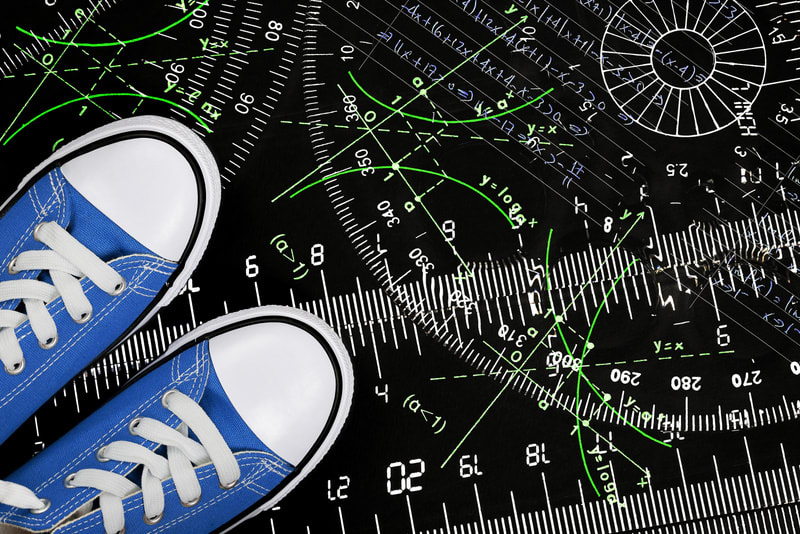 sneakers with rulers and mathematics on black surface, education concept