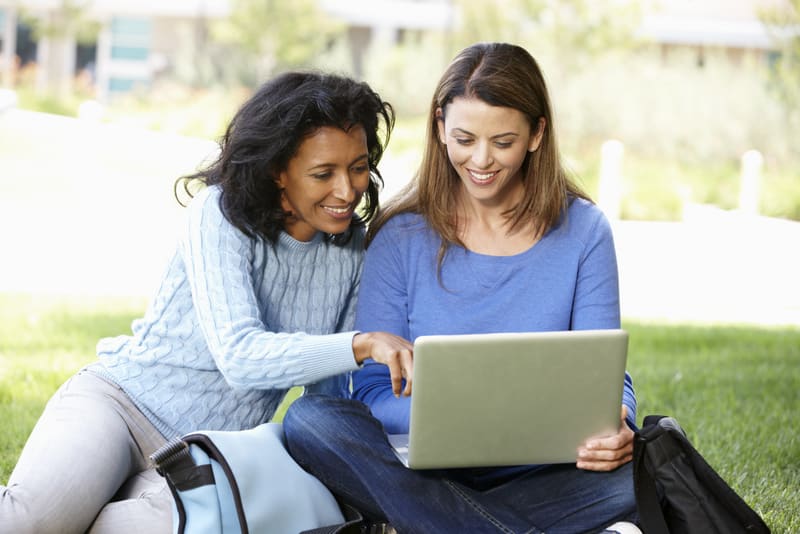 Women using laptop outdoors
