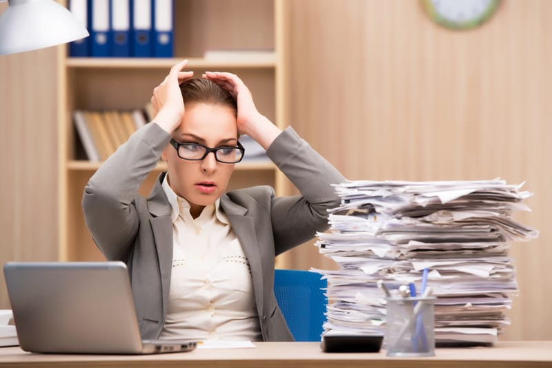 Businesswoman under stress from too much work in the office