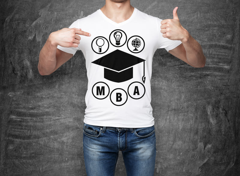 Close-up of a man pointing his finger to the chest with the sketch of the graduation hat. A concept of the MBA degree. shooting mark. Black chalk board on background.