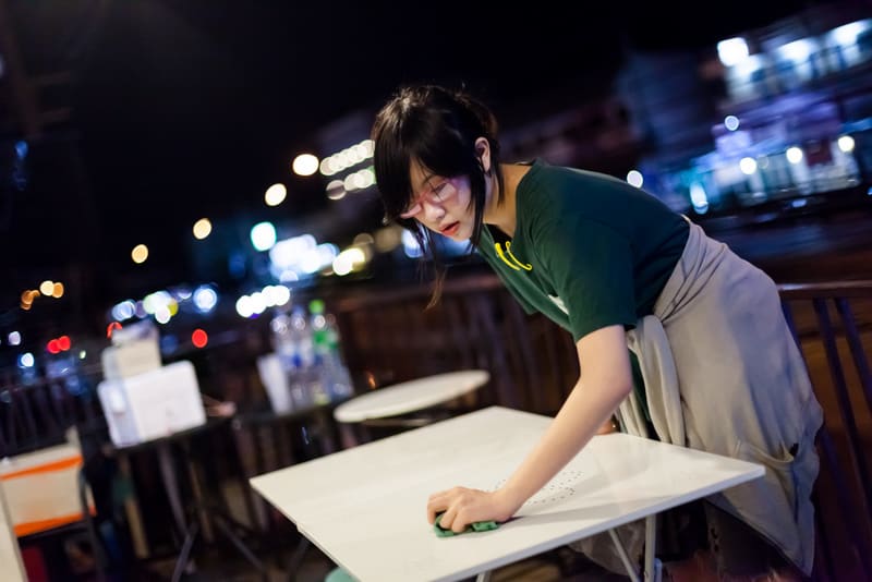 Young part time waitress clean up the table