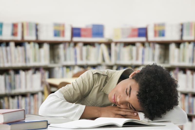 Hispanic boy sleeping in library