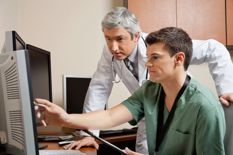 Mature doctor and male technician working together at clinic