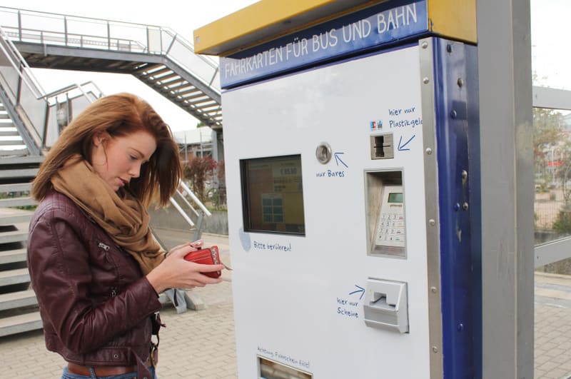 junge Frau am Fahrkartenautomat