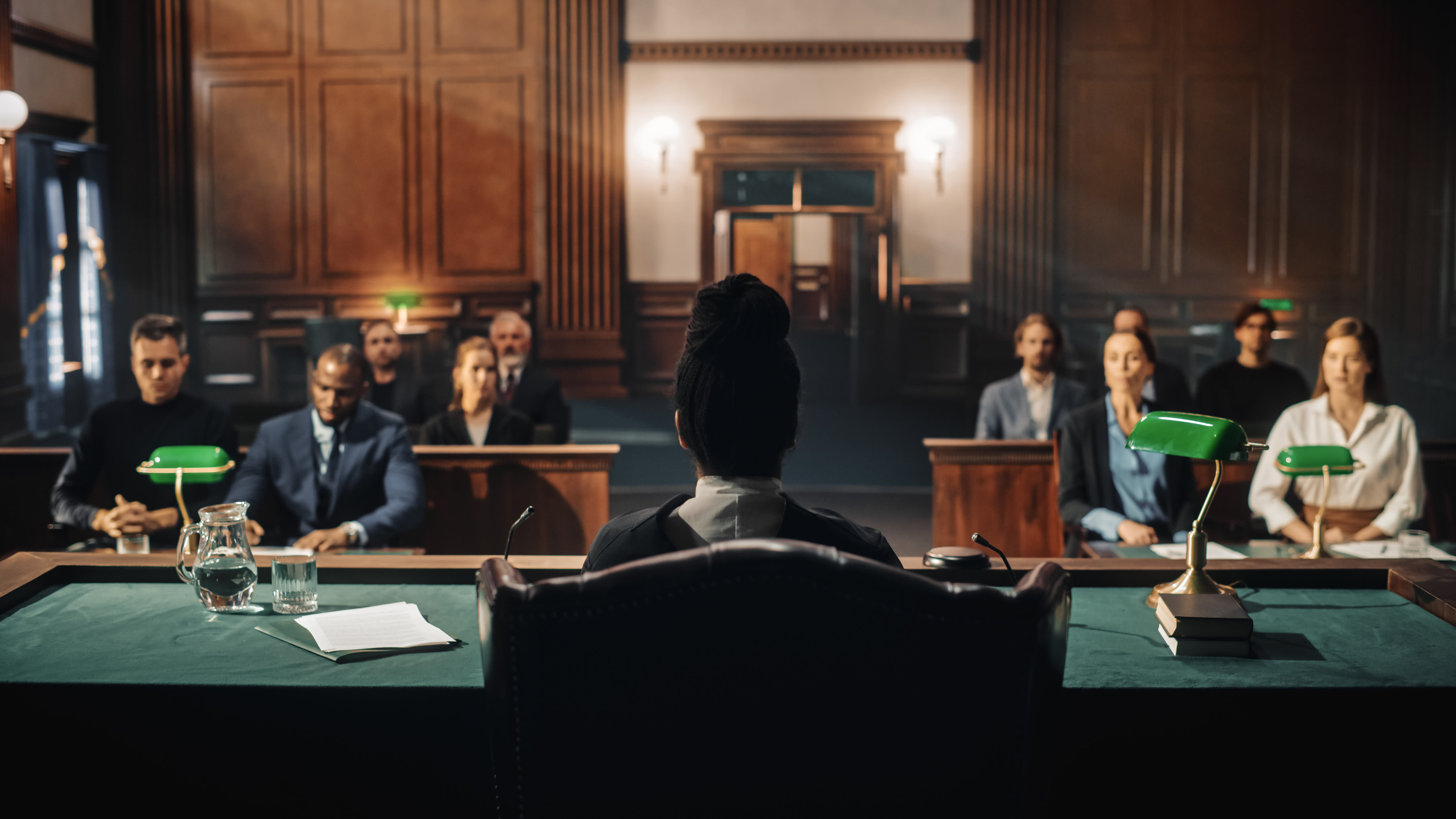 Mock trial: female judge and jury sit, start of a case hearing