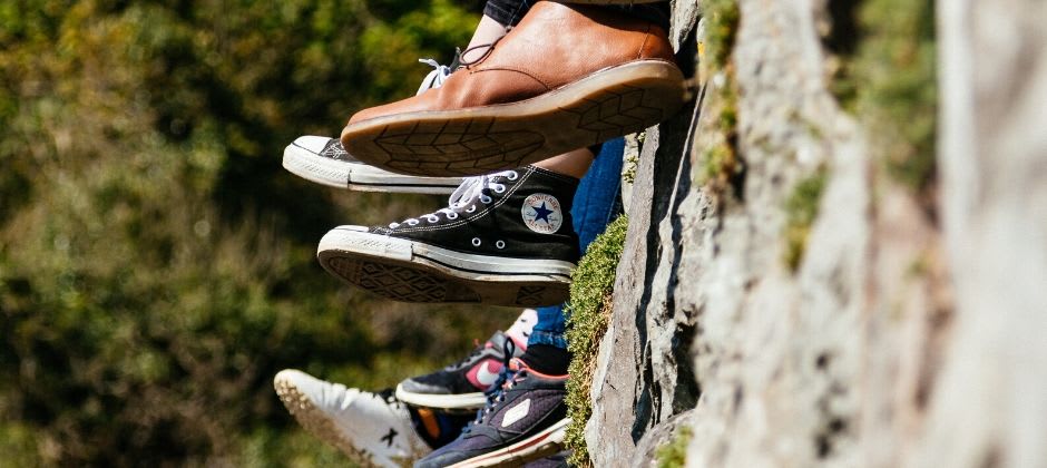 different shoes hanging over a stone wall