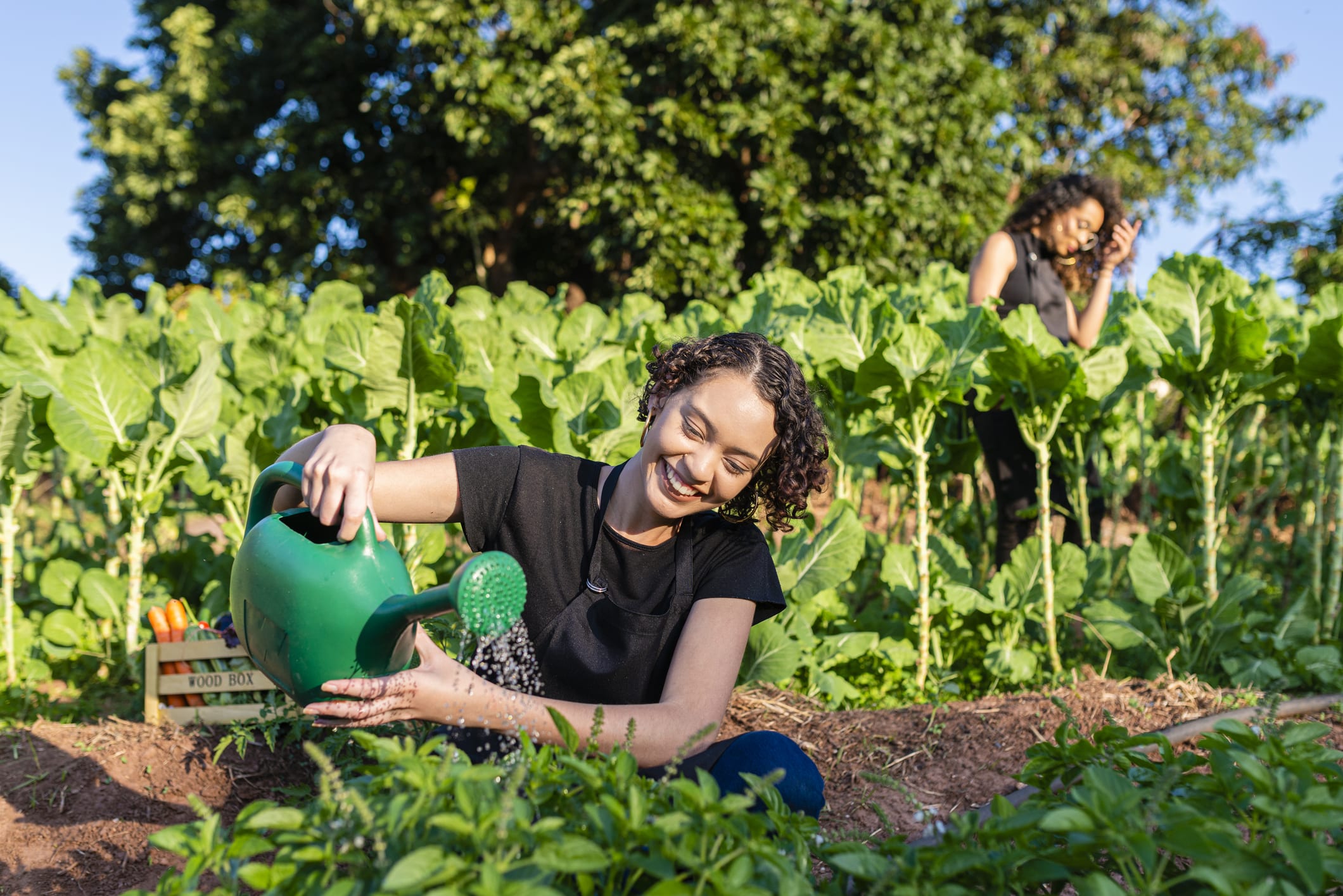 Girl watering organic products in her vegetable garden