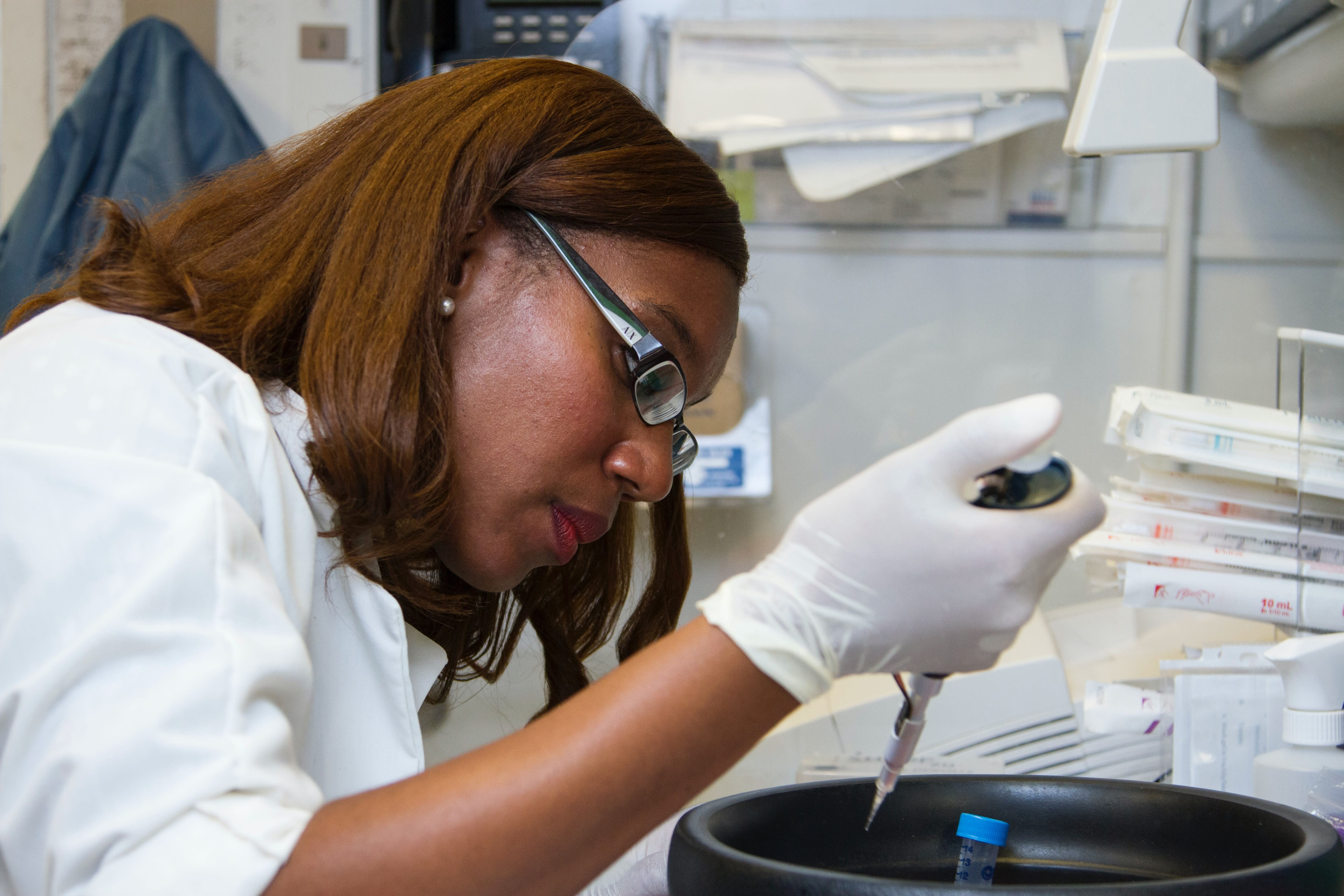 Chanelle Case Borden, Ph.D., a postdoctoral fellow in the National Cancer Institute's Experimental Immunology Branch, pipetting DNA samples into a tube for polymerase chain reaction, or PCR, a laboratory technique used to make multiple copies of a segment of DNA.