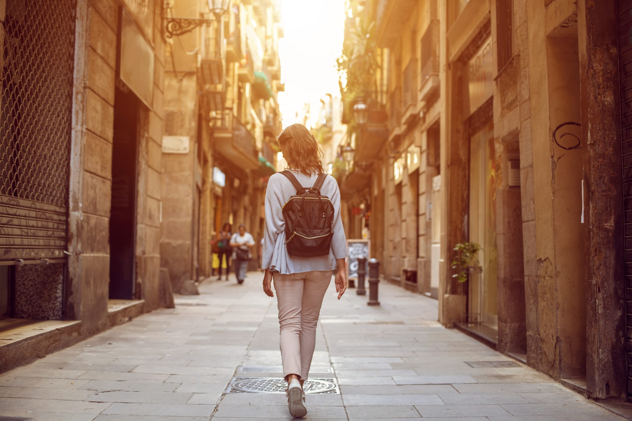 Traveling female walking on  European city street, tourism in Europe, travel background