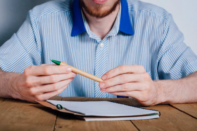Young man writing in notebook