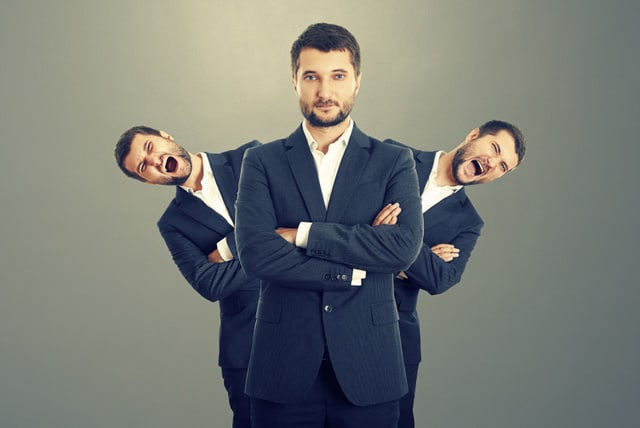 two screaming men behind confident businessman over dark background