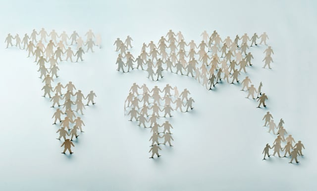 Paper cut figures standing and forming world map