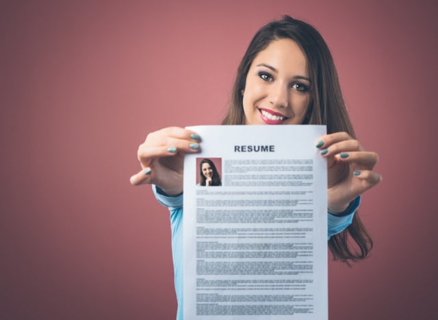 Young smiling woman holding her resume and applying for a job