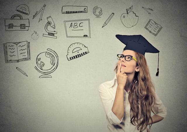 Young beautiful business woman with graduation hat looking up thinking about education isolated on gray wall background