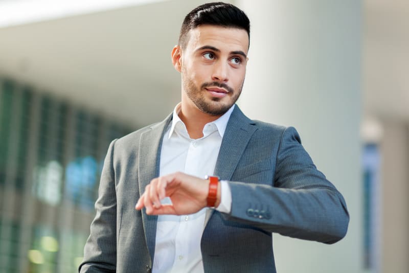 Handsome businessman checking time on his watch