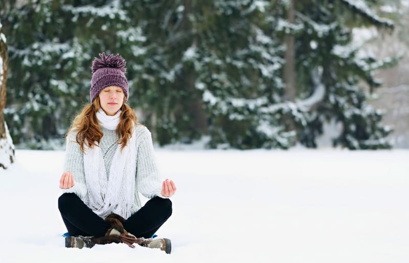 woman meditating at the park in winter