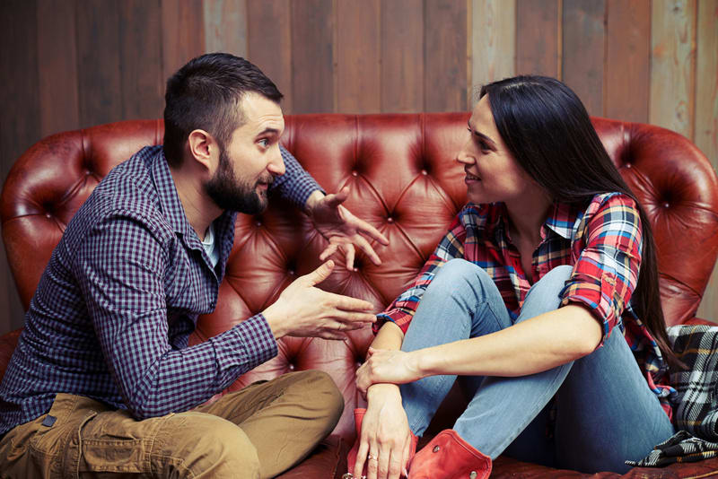 young couple sitting on sofa and have a interesting conversation