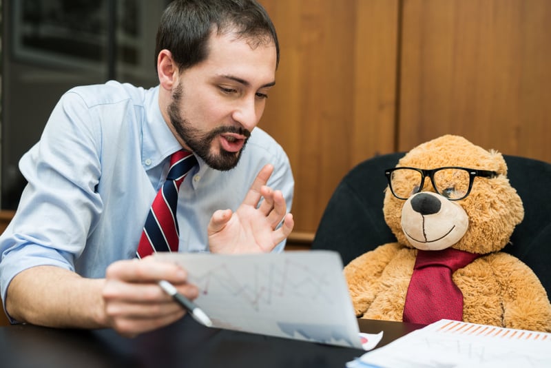 Businessman explaining a document to a teddy bear