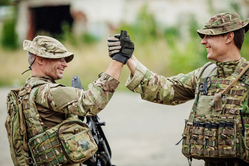 Soldier shaking hands on outdoor background